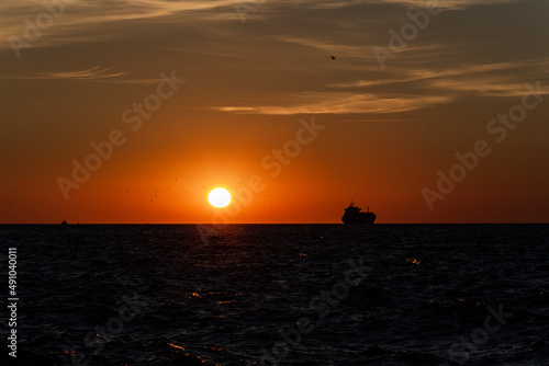 The silhouette of the ship on the horizon, going into the sunset. © ByAlice