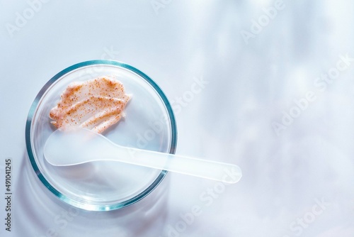 Cosmetic peeling scrub smudge textured on petri dish background
