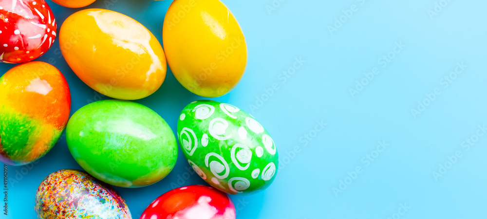 closeup, many beautiful painted Easter eggs as blue background. the concept for good friday, easter monday, spring full moon. copy space on right for text or design. top view, nobody, selective focus closeup, many beautiful painted Easter eggs as blue background. the concept for good friday, easter monday, spring full moon. copy space on right for text or design. top view, nobody, selective focus