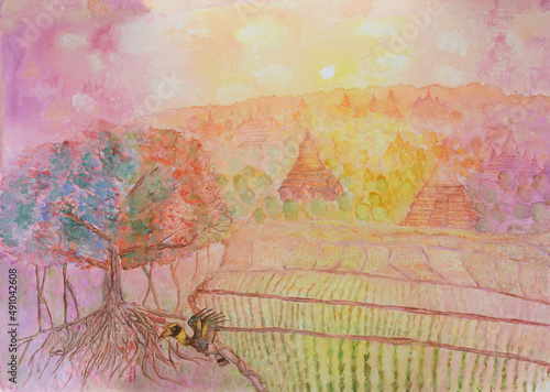 Terraced rice fields, a fig tree and hornbill bird eating fruit during sunset with ancient Buddhist temples in background. Mixed media hand painting