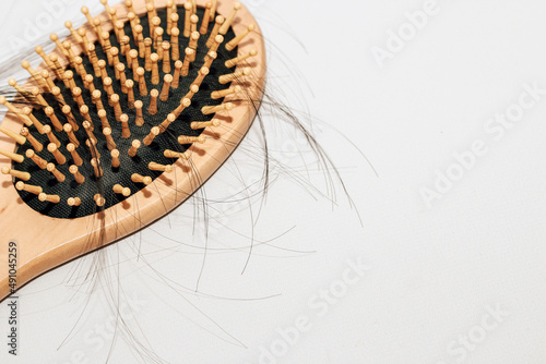 Wooden comb with fallen hair on it and scissors.