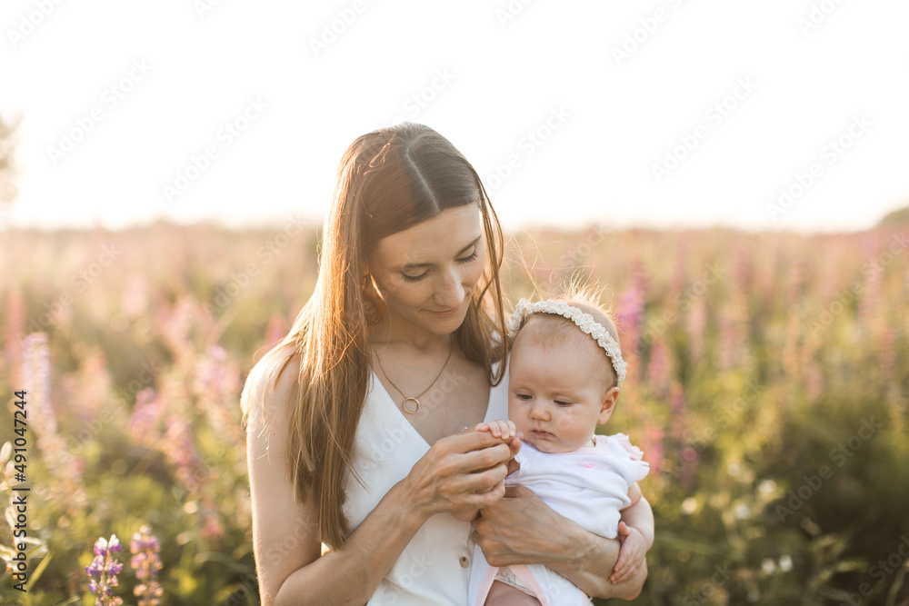 mother holds her child in her arms, nature, calm atmosphere - obrazy, fototapety, plakaty 