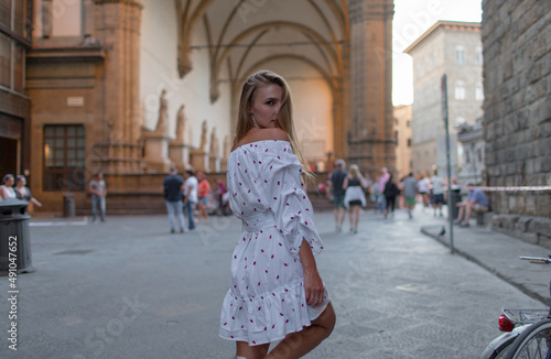 Young beautiful girl walks in the evening in the city