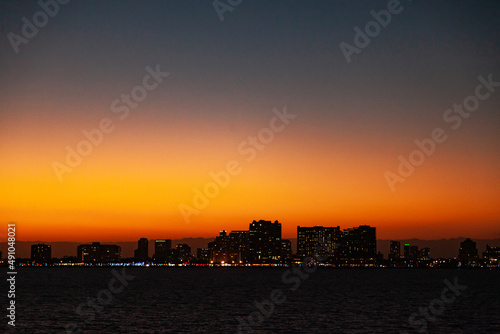 Night city of Fort Lauderdale on the coast of the Atlantic Ocean, against the backdrop of twilight with an orange sky. © Сергей Жмурчак
