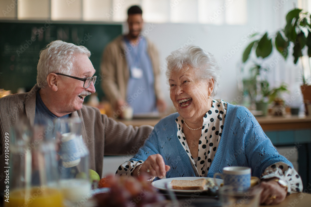 Smiling elderly woman and man enjoying breakfast in nursing home care center. Smiling elderly woman and man enjoying breakfast in nursing home care center.