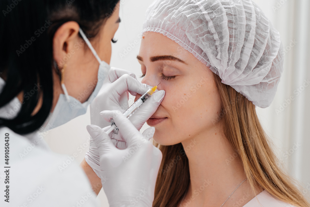Cosmetic procedure for filling the nasolacrimal furrow and mesotherapy around the eyes for a young beautiful girl. Modern cosmetology. Cosmetic procedure for filling the nasolacrimal furrow and mesotherapy around the eyes for a young beautiful girl. Modern cosmetology.