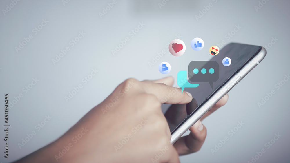Live Chat on Communication social network Concept. Person hand using smartphone typing, playing social media chatting conversation in chat box icons pop up. Live Chat on Communication social network Concept. Person hand using smartphone typing, playing social media chatting conversation in chat box icons pop up.
