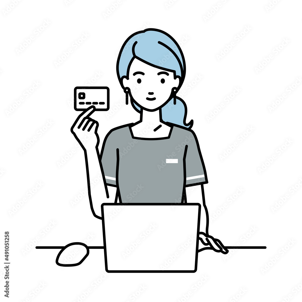デスクで座ってPCを使いながらクレジットカードを手に持っているエステ店員・受付の女性 デスクで座ってPCを使いながらクレジットカードを手に持っているエステ店員・受付の女性