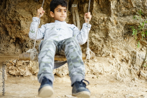 A young boy swinging in mountain area