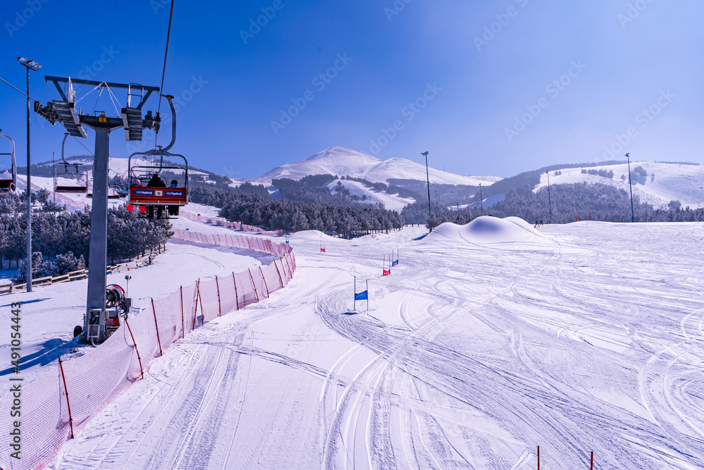 Ski slopes and Ski lifts. Small pine trees with snow. Mountain skiing and snowboarding. View of Erzurum city from Palandoken mountain Ski slopes and Ski lifts. Small pine trees with snow. Mountain skiing and snowboarding. View of Erzurum city from Palandoken mountain
