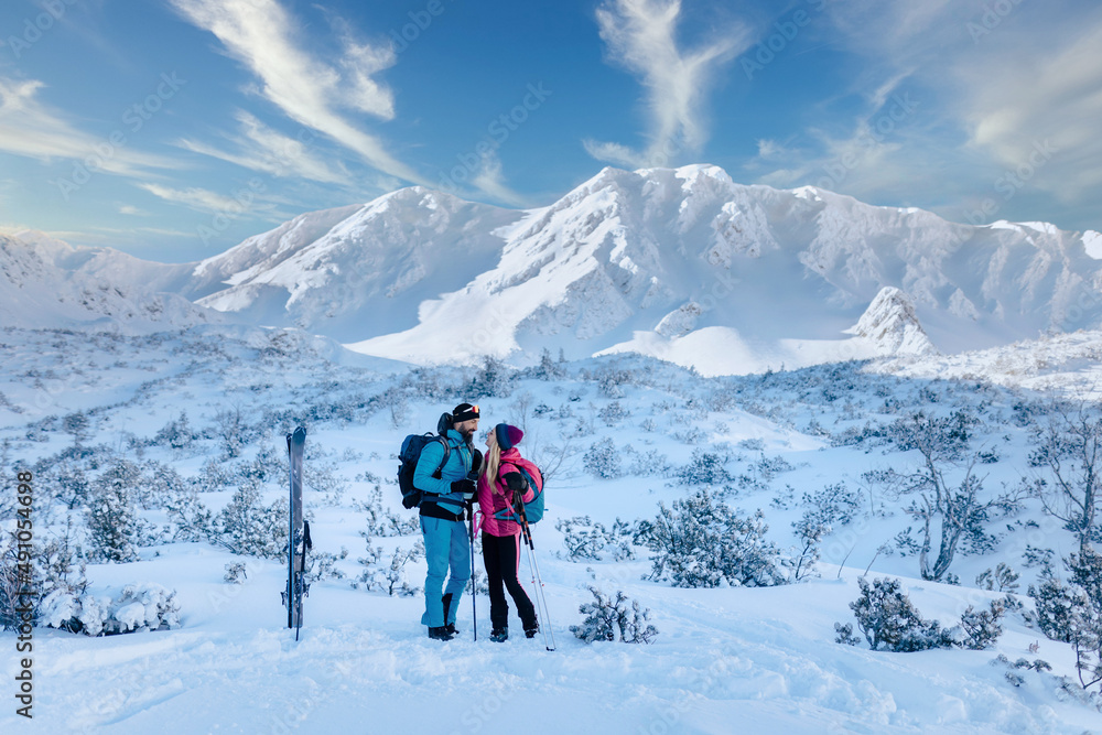 Ski touring couple taking break on the top of mountain in the Low Tatras in Slovakia.
