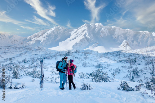 Ski touring couple taking break on the top of mountain in the Low Tatras in Slovakia.