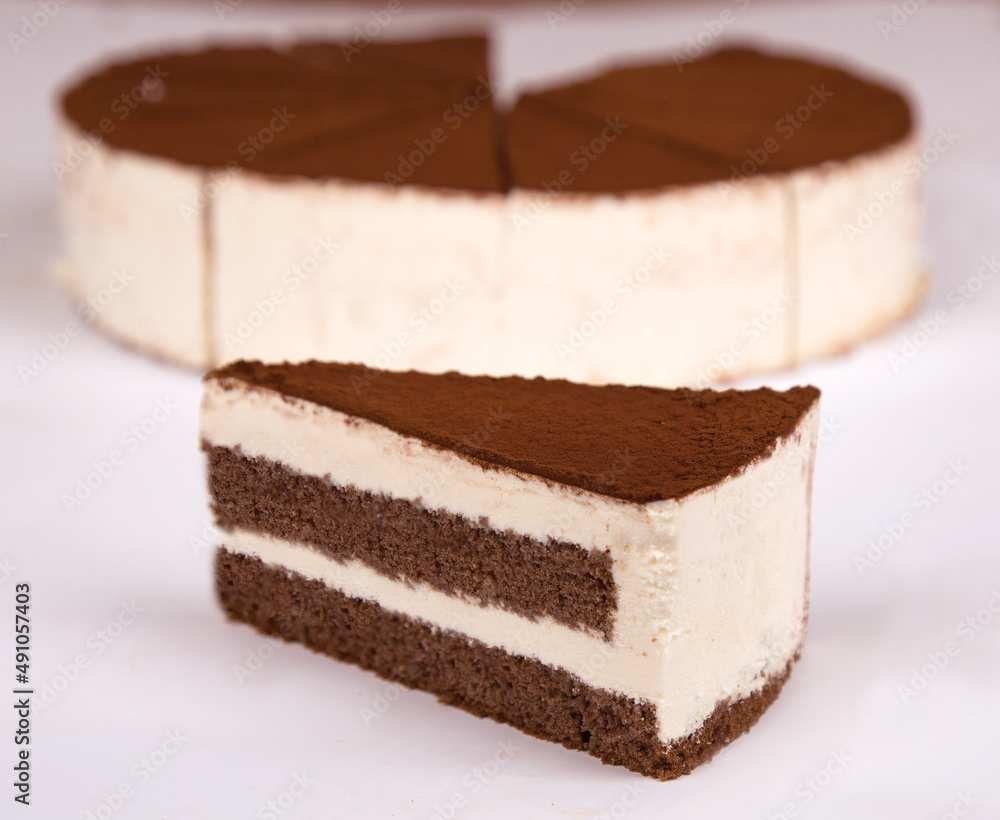 Tiramisu cake with cocoa decoration on a plate. white background. Tiramisu cake with cocoa decoration on a plate. white background.
