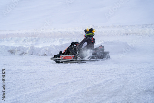 Go karting on icy track in winter. Adult karting driver in action on outdoor icy track