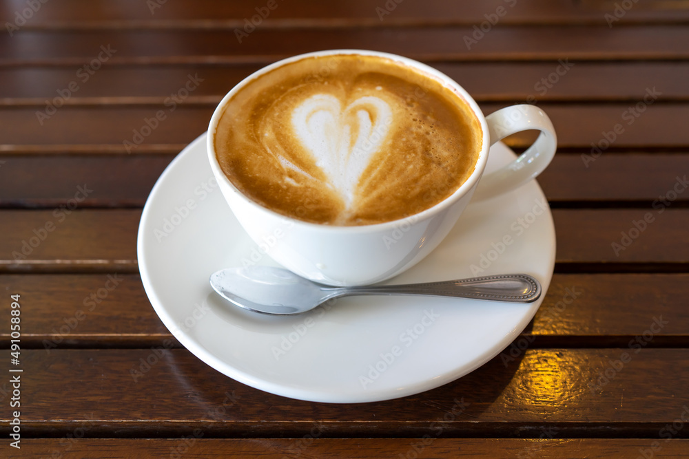 Latte coffee or cappuccino coffee in white cup on wooden table Latte coffee or cappuccino coffee in white cup on wooden table