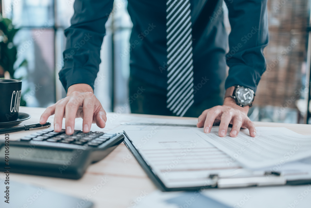 Accountant working on calculator to calculate company data, document and report on desk office. Accounting business concept. Accountant working on calculator to calculate company data, document and report on desk office. Accounting business concept.