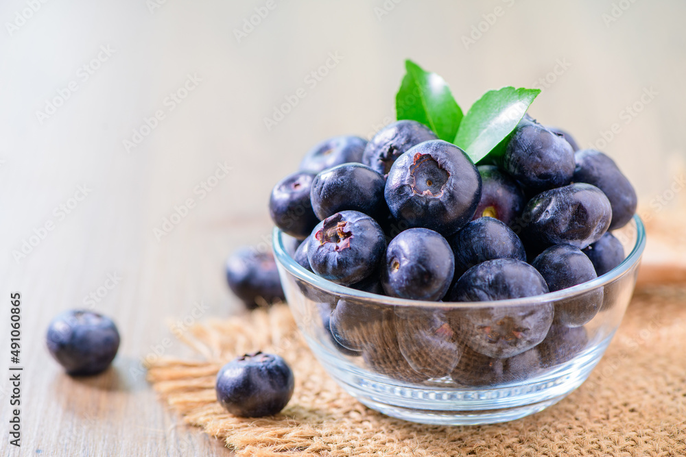 Fresh organic blueberries in a glass bowl on wood background, Fresh organic blueberries in a glass bowl on wood background,