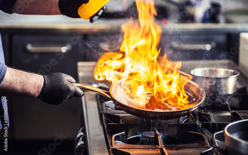 Detail of a flambe in a pan with flames reaching high