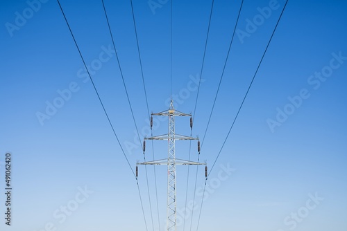 High voltage columns  in the background with blue sky and clouds. Prices of electricity  consumption  ecology.