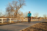 senior male cyclist is riding a gravel bike on one of numerous bike trails in northern Colorado in fall or winter scenery - Poudre River Trail near Windsor