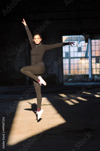 Ballerina jumping and dancing in abandoned building. 