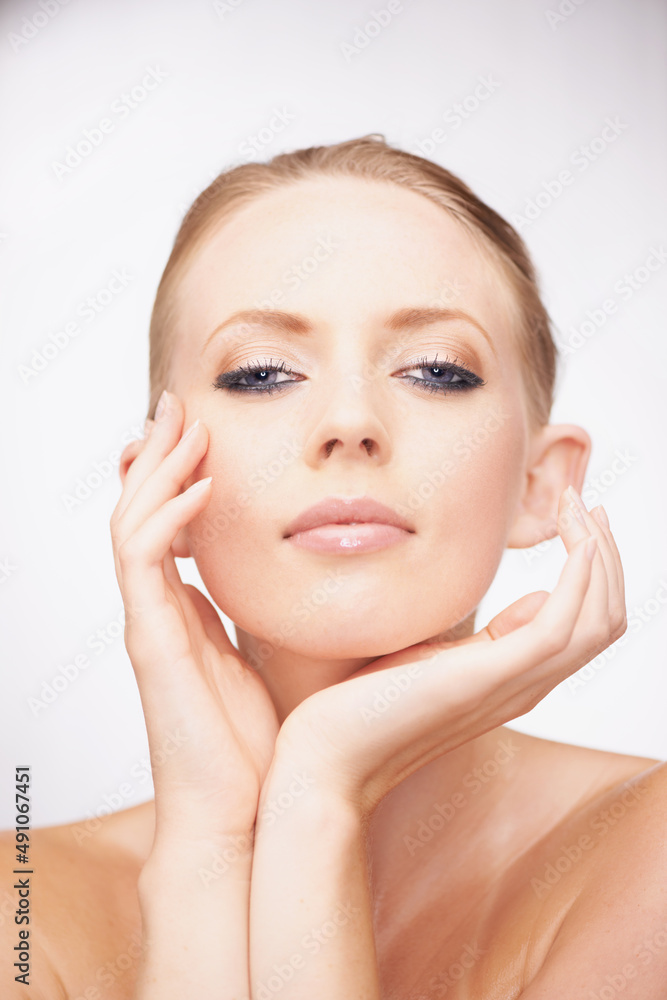 Feeling her flawless complexion. Studio shot of a beautiful young woman touching her flawless skin. Feeling her flawless complexion. Studio shot of a beautiful young woman touching her flawless skin.