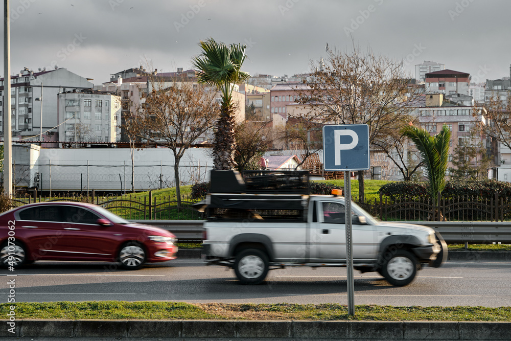 Selective focus photo, motion of cars and automobiles and Parking sign.