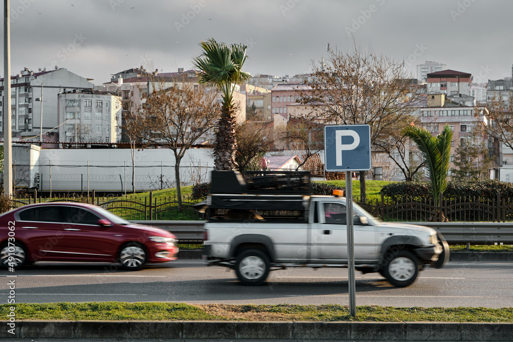 Fototapeta premium Selective focus photo, motion of cars and automobiles and Parking sign.
