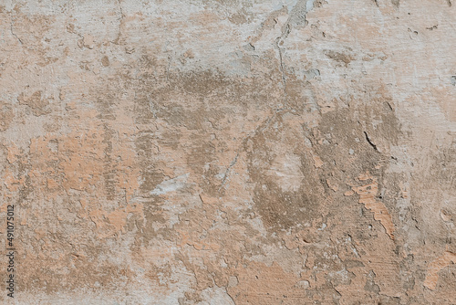 Plastered weathered wall with detailed texture. Beige grunge background. A concrete surface with damages.