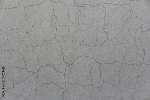 An old cement wall, abstract grey background. A cracked concrete wall texture with scratches.