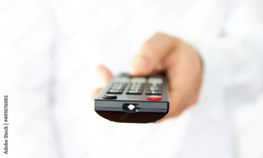 Remote control in hand, isolated on a light background. Remote control in hand, isolated on a light background.
