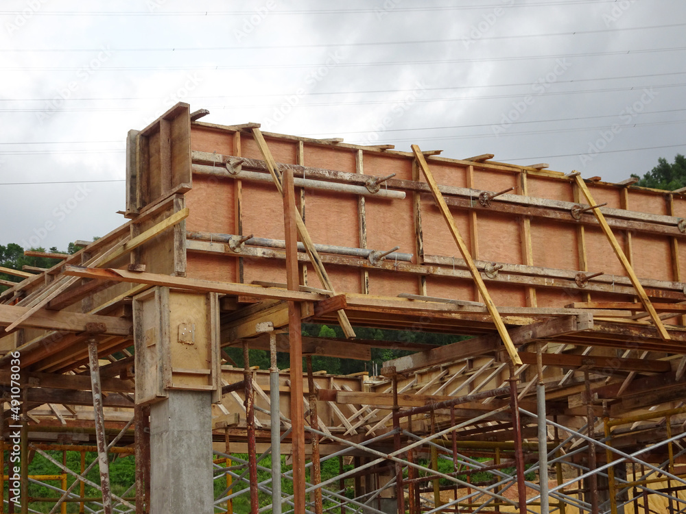 KUALA LUMPUR, MALAYSIA - JULY 7, 2021: Beam and column formwork installed at a construction site. Molds are made of wood and plywood. Be the basis of form to reinforced concrete. KUALA LUMPUR, MALAYSIA - JULY 7, 2021: Beam and column formwork installed at a construction site. Molds are made of wood and plywood. Be the basis of form to reinforced concrete.