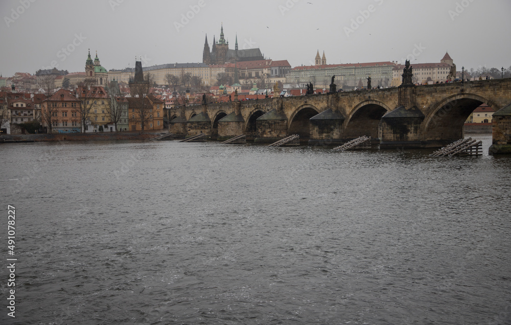 winter rainy day in Prague - view of Vltava river, Charles bridge and Prague castle