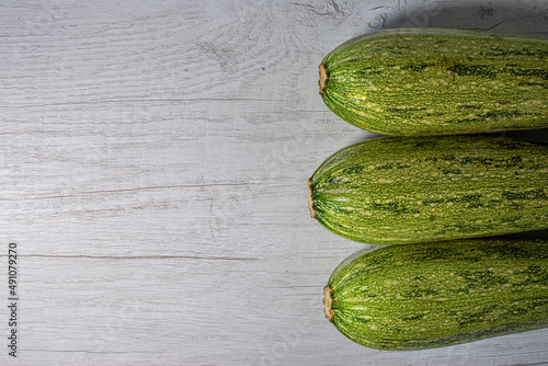 minimalist photo of lifestyle and fresh food. and zucchini. white wood texture. white wood texture