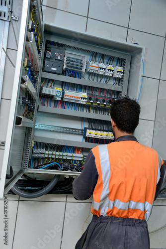 electrician worker checking voltage of the electric power switch in fuse board