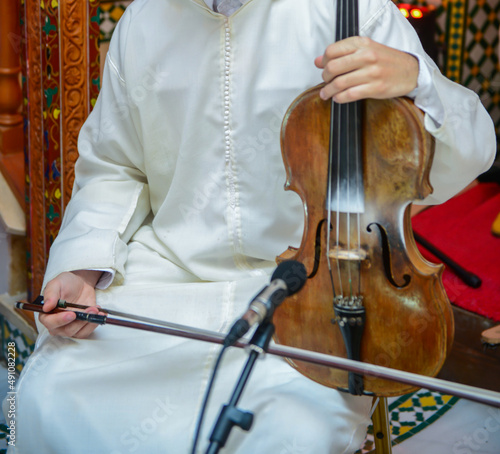 A Moroccan player wearing a djellaba plays a violin called Andalusian art in Morocco and Algeria