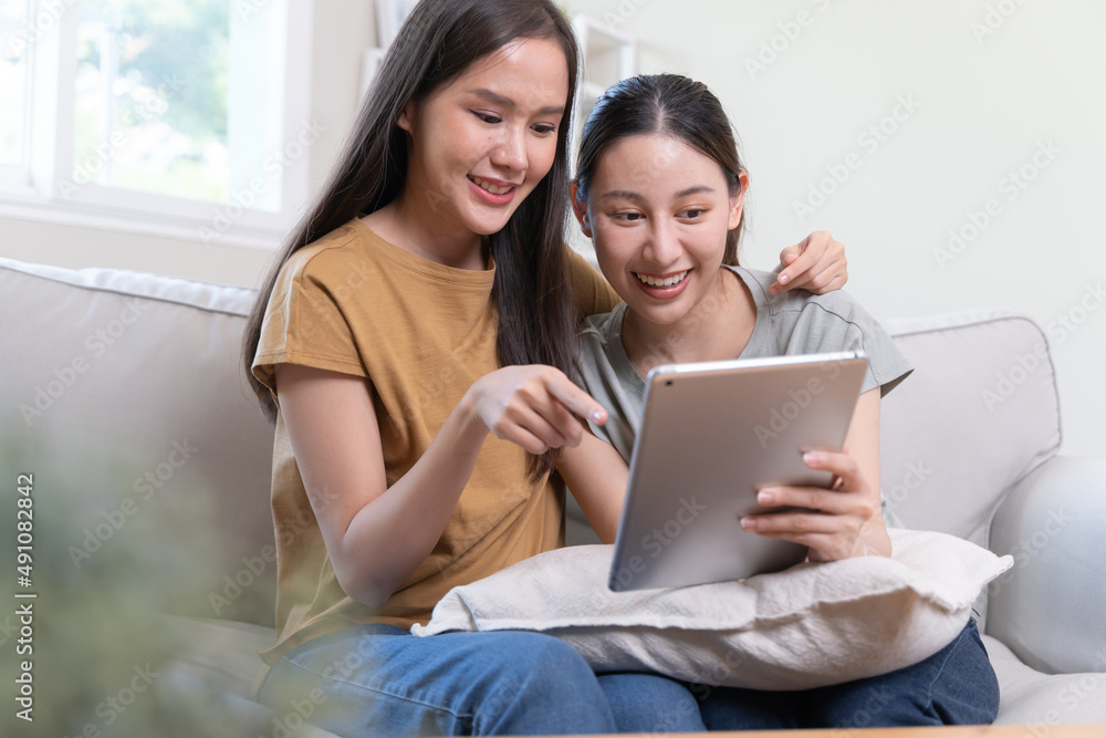 two happy women lesbian couple watching series on the internet via touchpad relax. two happy women lesbian couple watching series on the internet via touchpad relax.