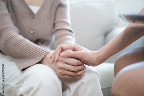psychologist touching hands and encouraging stressed woman have by about mental health problem photo