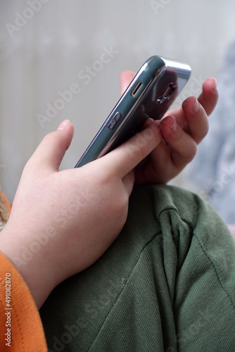 close-up of a child playing with a smartphone, very close-up of hand and mobile phone,