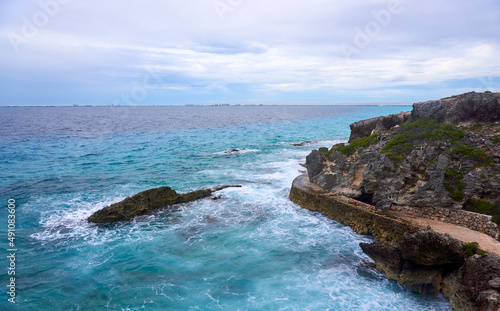 rocky road in punta sur of isla mujeres, in the background cancun on a cloudy day, fine art photography, long exposure