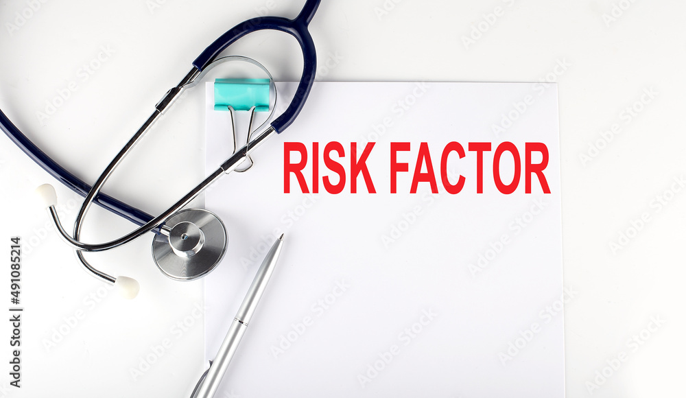 RISK FACTOR text written on the paper with a stethoscope. Medical concept. RISK FACTOR text written on the paper with a stethoscope. Medical concept.
