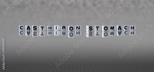 cast iron stomach word or concept represented by black and white letter cubes on a grey horizon background stretching to infinity