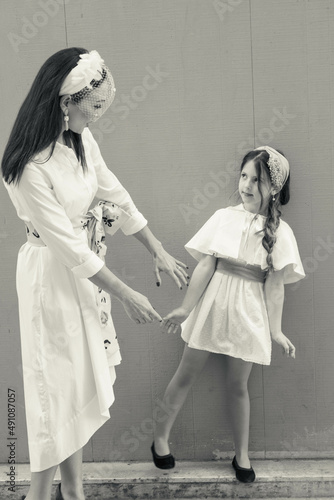 Black and white picture of chic and elegant mother and daughter playing and dancing in the street looking like a classic film