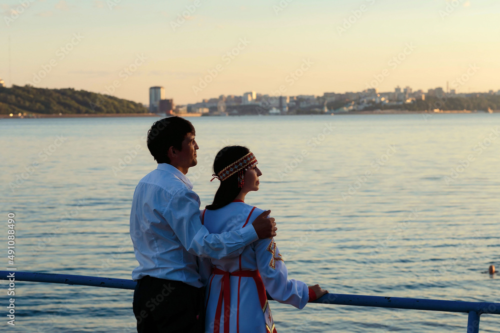 a girl in national Chuvash clothes and her boyfriend on the river bank