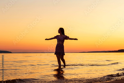 a girl on the riverbank at sunset