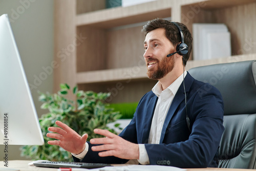 Fotografie Representive businessman online training wearing a suit and headset, with positi