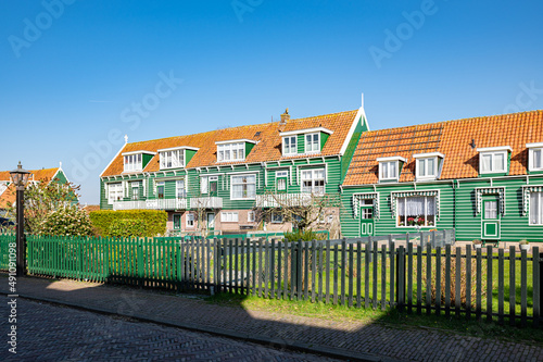 Scenic green painted wooden houses with orange colored roofs in the historic village of Marken, Netherlands