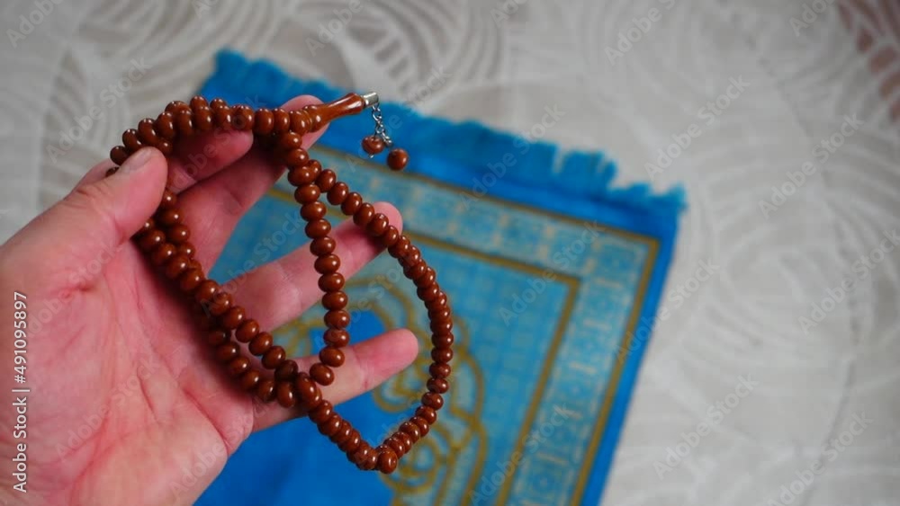 A blue, prayer rug, in the house, of a Muslim, his rosary, next to it, a prayer, rug, for worship in Islam, A blue, prayer rug, in the house, of a Muslim, his rosary, next to it, a prayer, rug, for worship in Islam,