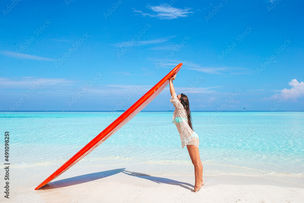 Beautiful surfer woman ready to surfing in turquoise sea, on stand up paddle board at exotic vacation Beautiful surfer woman ready to surfing in turquoise sea, on stand up paddle board at exotic vacation