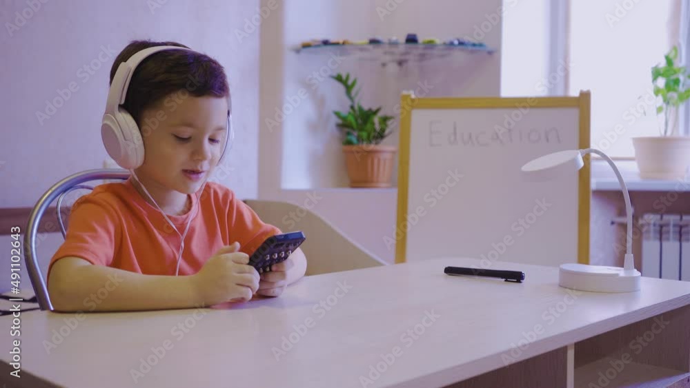 A little boy learns music at an online school and sends an air kiss A little boy learns music at an online school and sends an air kiss